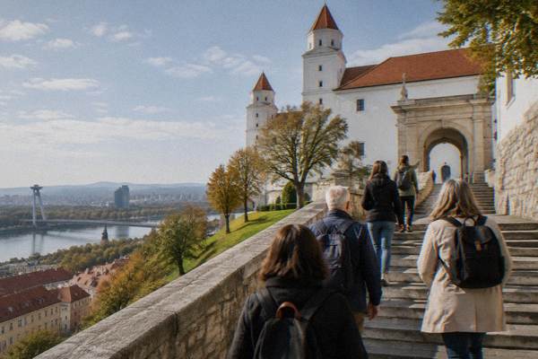 Small group on a guided walk below a castle wall