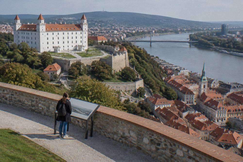 A visitor reading an information panel outside Bratislava Castle on the castle hill