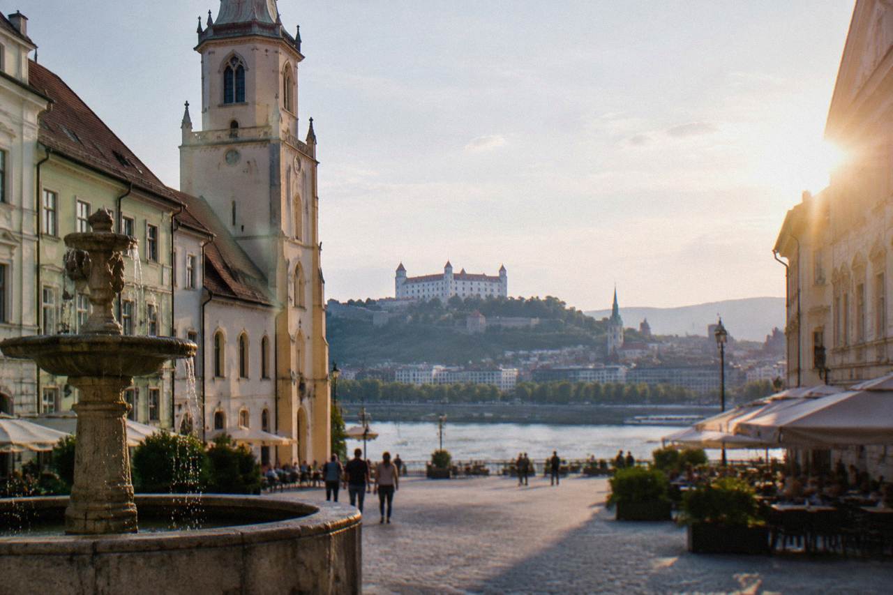 Two European capital city skylines along the Danube river seen from a distance