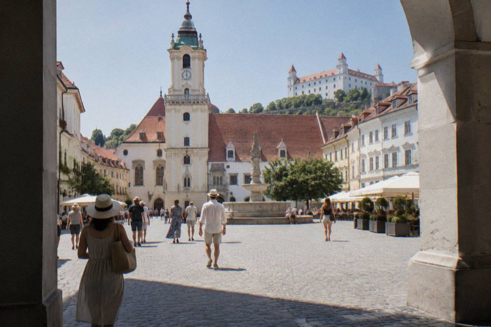 People walking on a cobbled square in central Bratislava on a summer afternoon