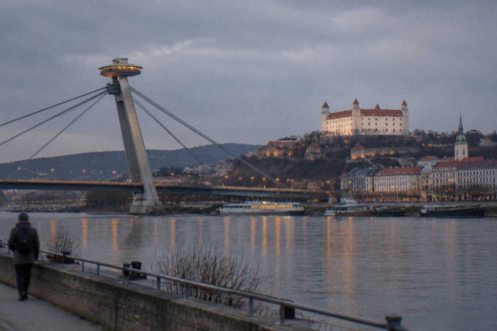 The UFO observation deck on Bratislava's SNP bridge lit up above the Danube at dusk