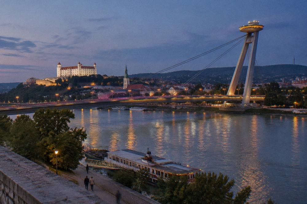 The UFO observation deck on the Most SNP bridge glowing above the Danube after dark