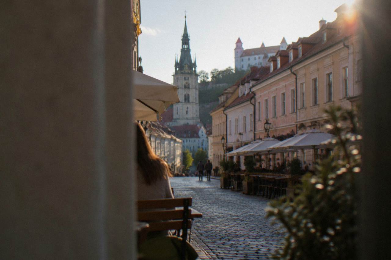 Bratislava Old Town square with pastel facades and a church tower on a clear afternoon