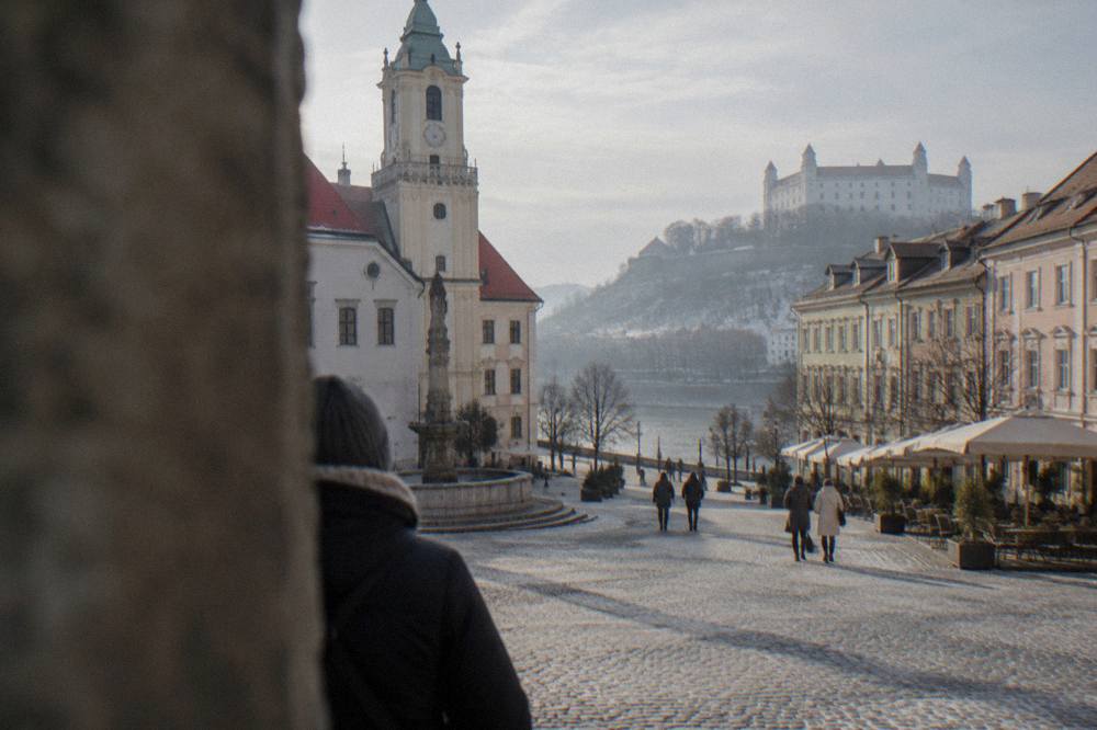 Visitors walking up the path toward the ruins of Devin Castle above the rivers in winter light