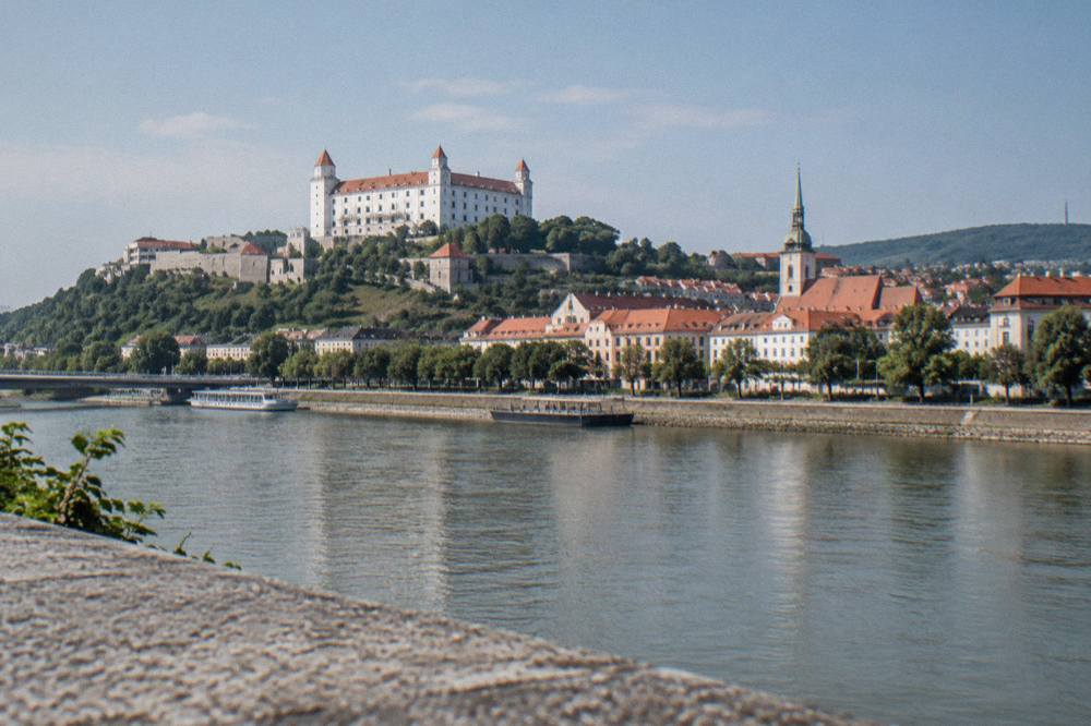 Bratislava Castle standing above the Danube riverfront with the Old Town rooftops below