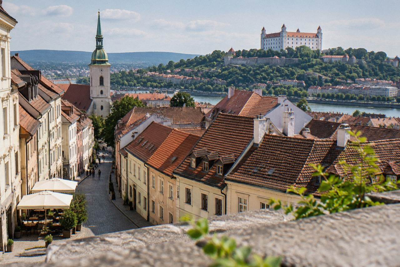 View over Bratislava Old Town rooftops toward the castle on its hill above the Danube