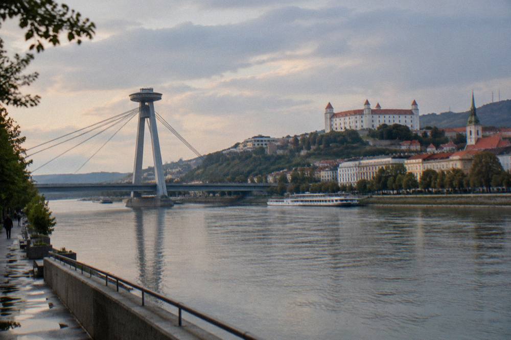 Evening light on the Danube riverfront with the UFO observation deck on the bridge above the water
