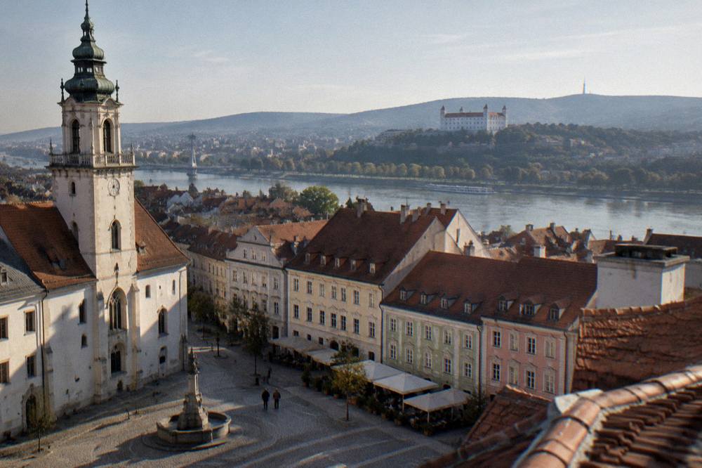 A view across rooftops and the Danube toward the hills outside Bratislava
