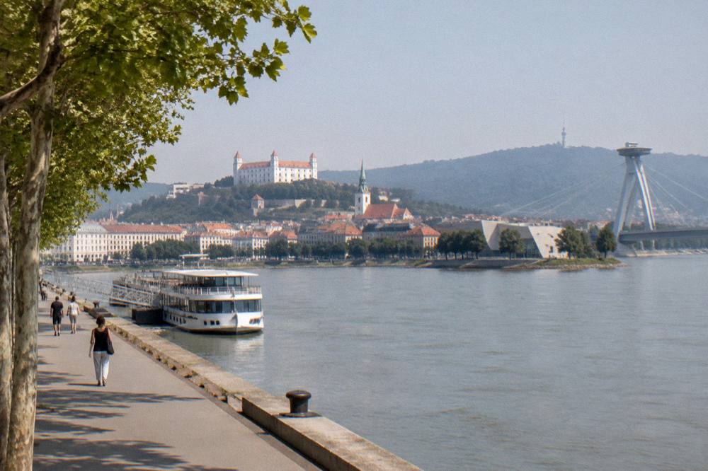A modern art museum building on a peninsula at the edge of a wide river