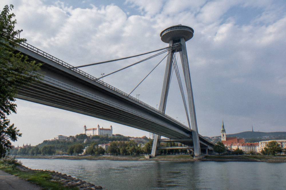 The UFO observation deck structure on the Most SNP bridge seen from a riverside path