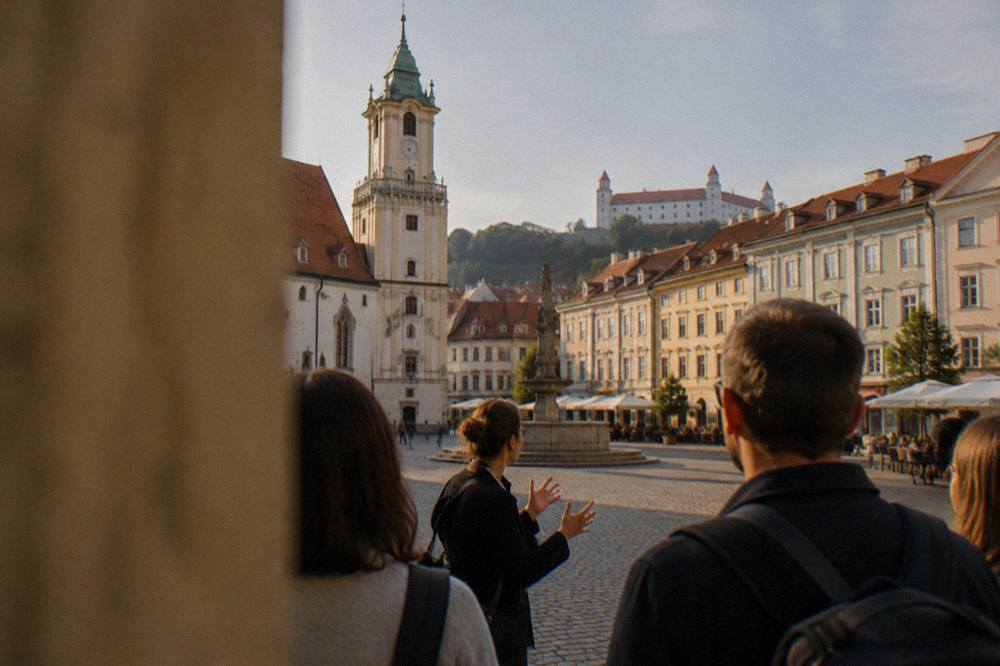 A guide speaking to a small group of visitors on a Bratislava street