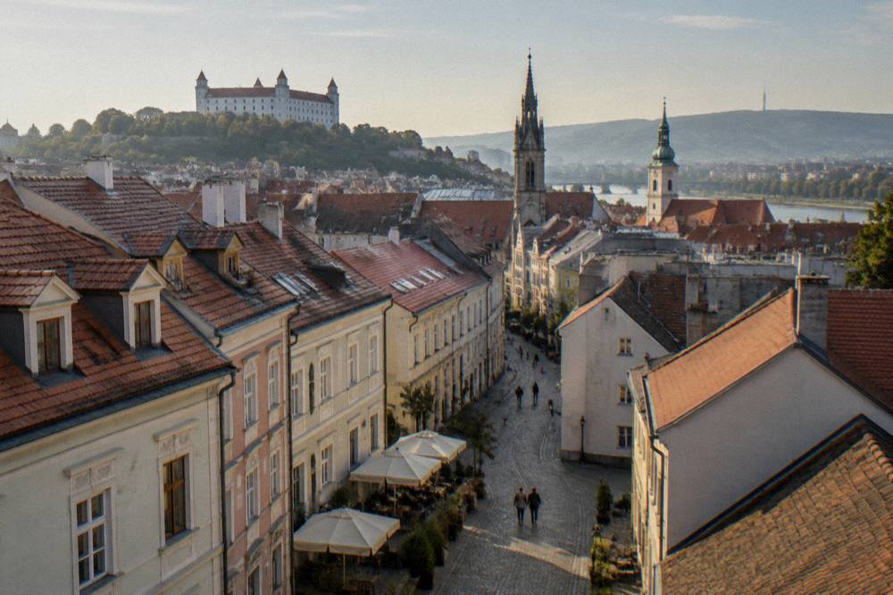 The Old Town rooftops of Bratislava seen from the castle hill with church towers in the distance