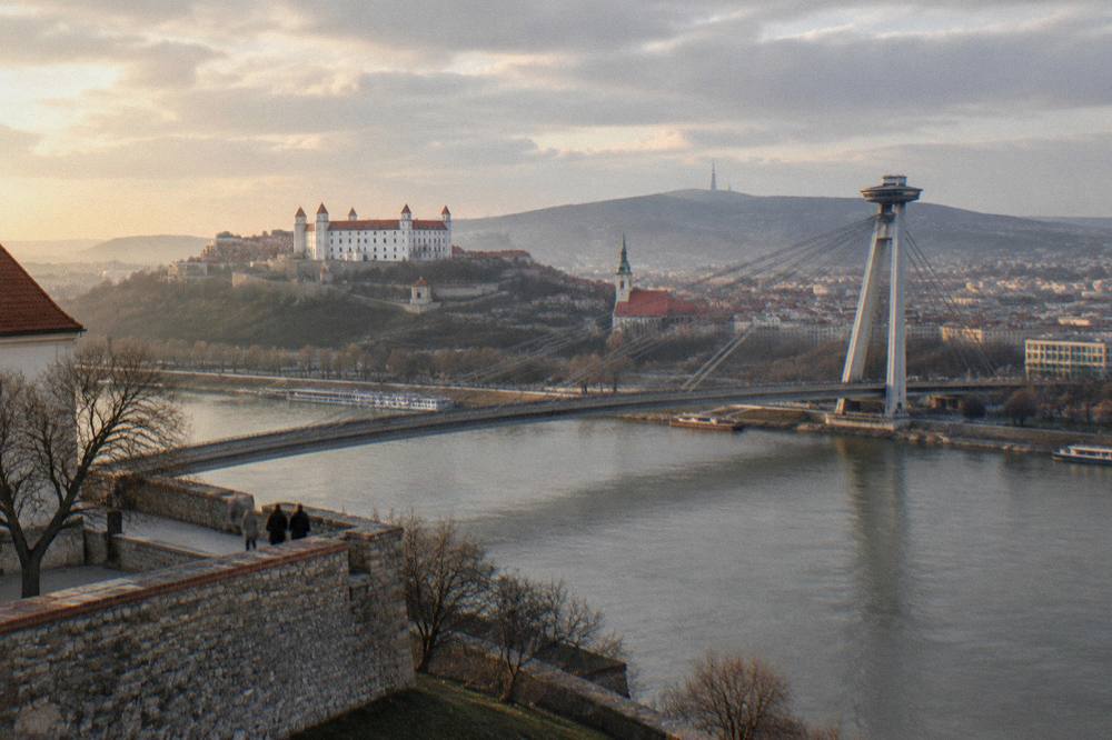 The SNP bridge and the Danube river seen from the grounds of Bratislava Castle at golden hour