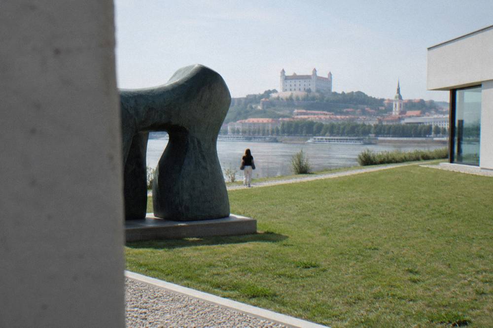 Sculpture displayed on open ground beside the museum near the riverbank