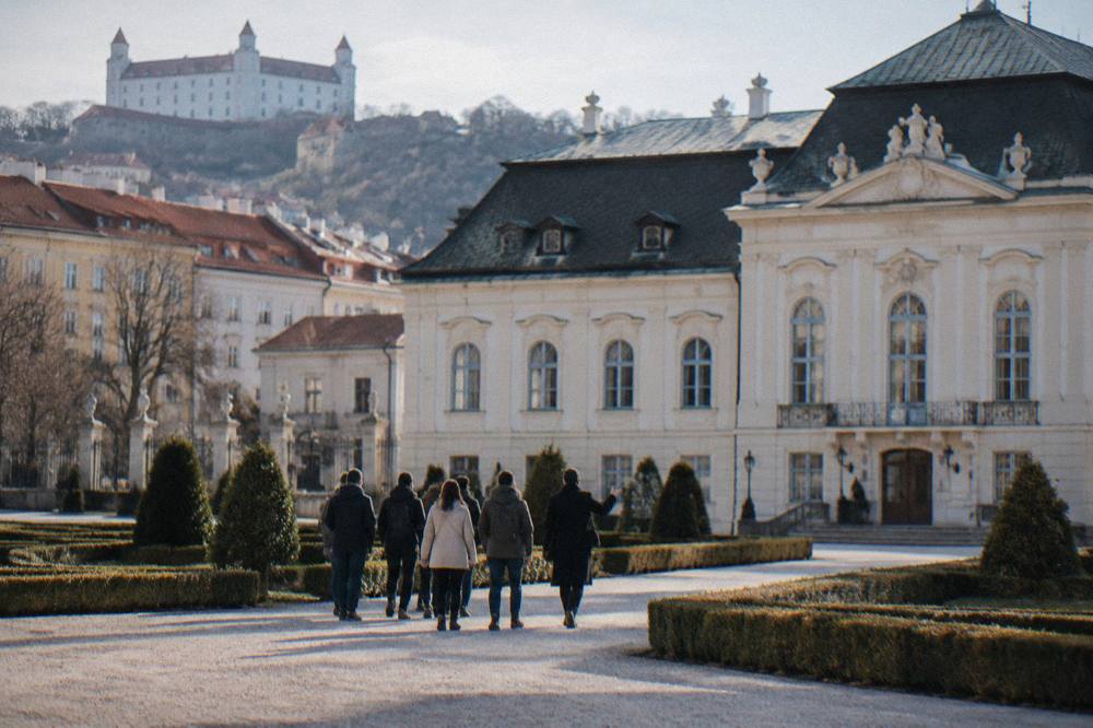 A small group following a guide through an old European square