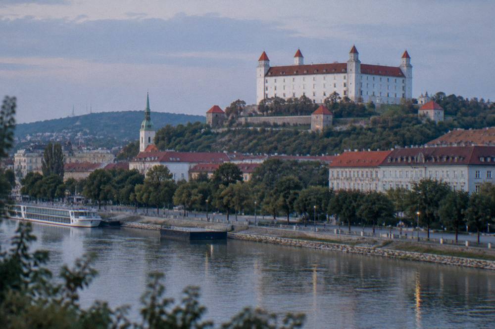 The Danube riverfront promenade below Bratislava Castle on a bright day