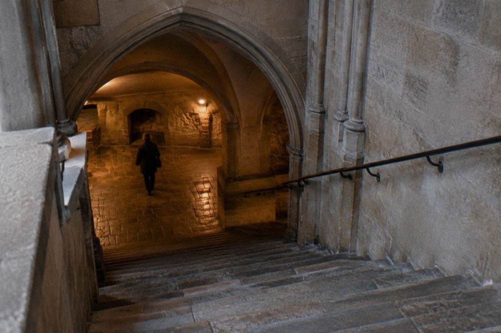 Stone stairway leading from a church interior down toward a low vaulted crypt space