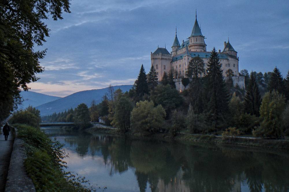 An old stone castle on a hill above a river valley