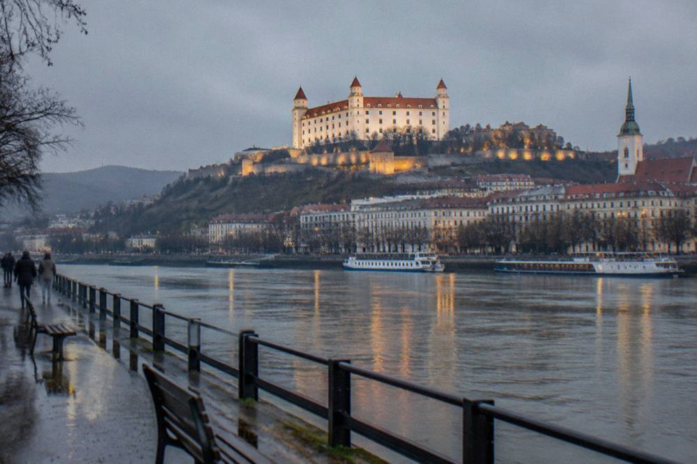 The Bratislava Castle illuminated above the river at dusk