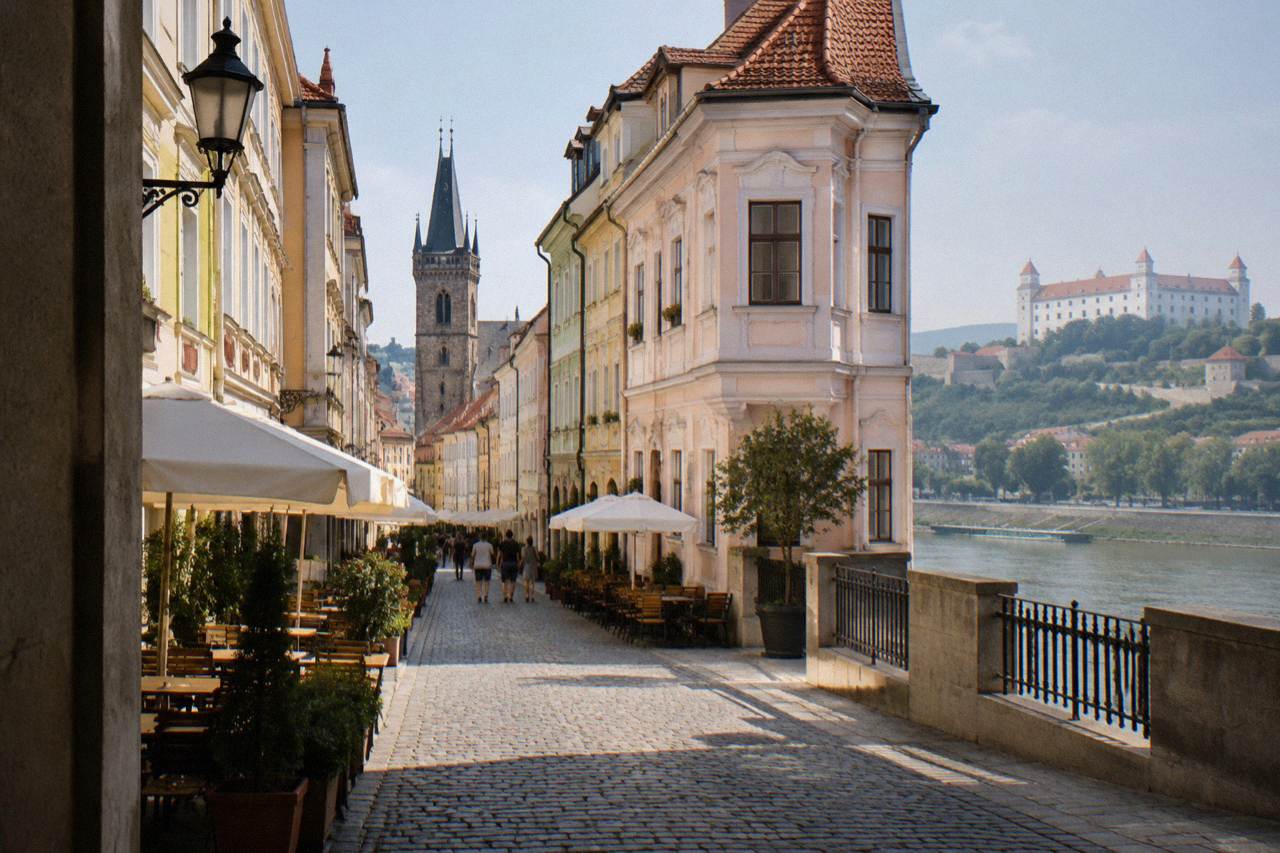 Colourful baroque buildings facing a river embankment in a central European old town