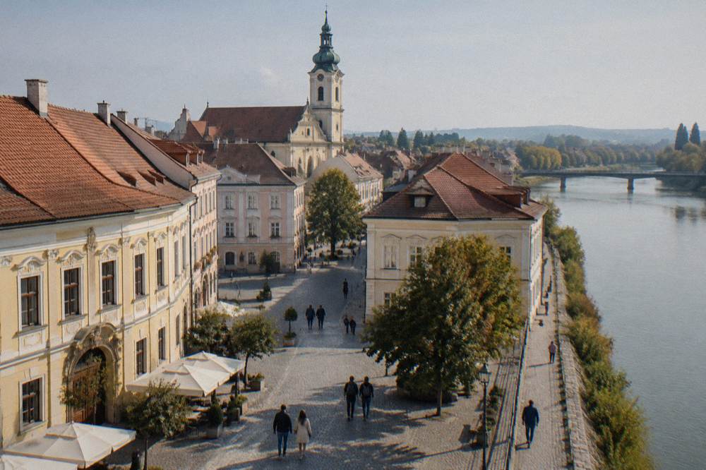 Visitors walking a cobbled square lined with baroque town houses