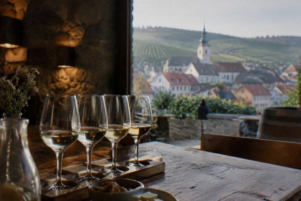 A tasting flight of white wines on a wooden cellar table