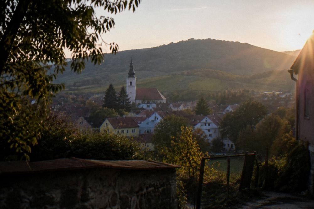 Wooded Small Carpathians hills above a town at golden hour