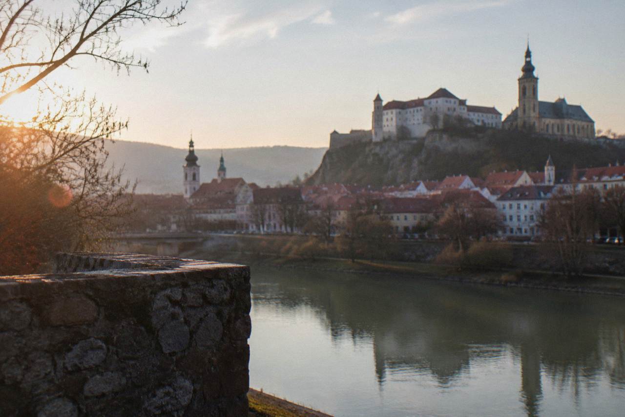 A hilltop castle complex above a Slovak town with church towers and rooftops below