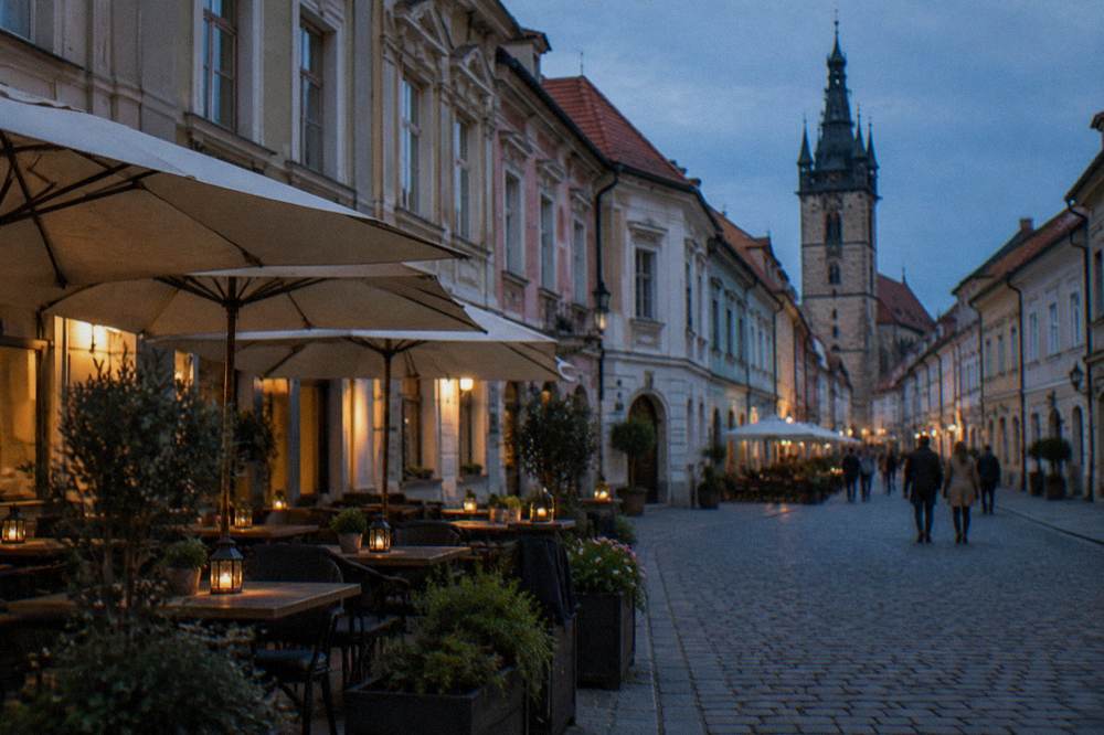 An old town square with coloured facades and a cafe terrace in a Slovak regional city