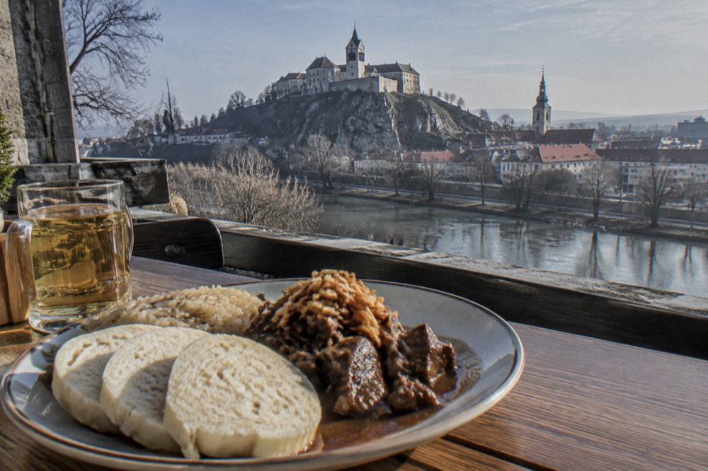 A plate of Slovak food on a wooden table in a small restaurant