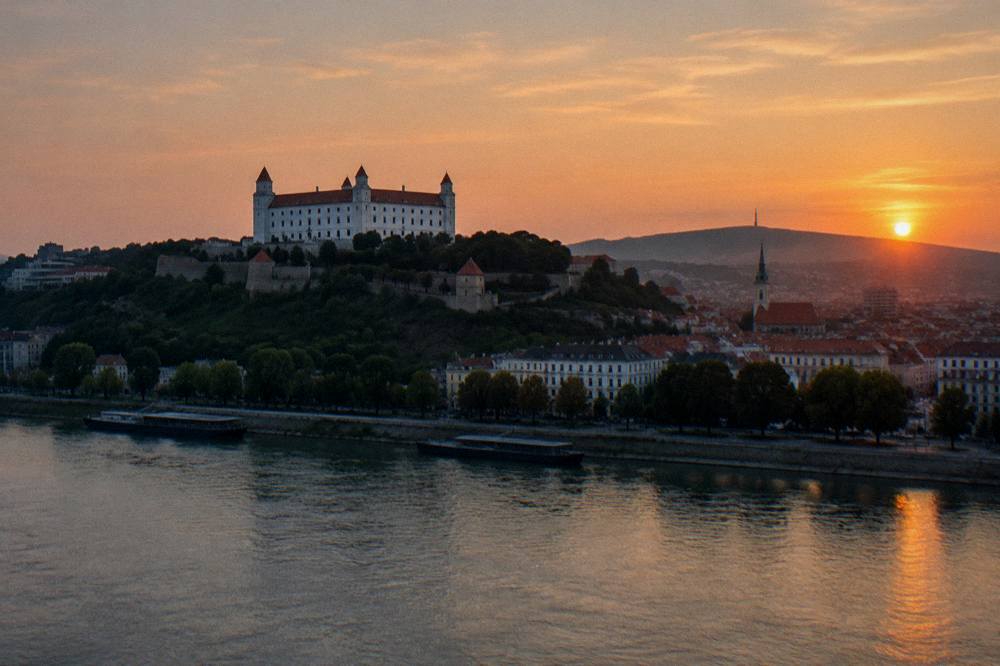 The Bratislava castle silhouette above the Danube river at sunset