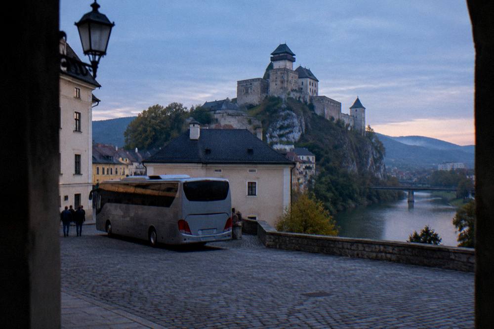 A coach parked on a cobbled square in a small castle town