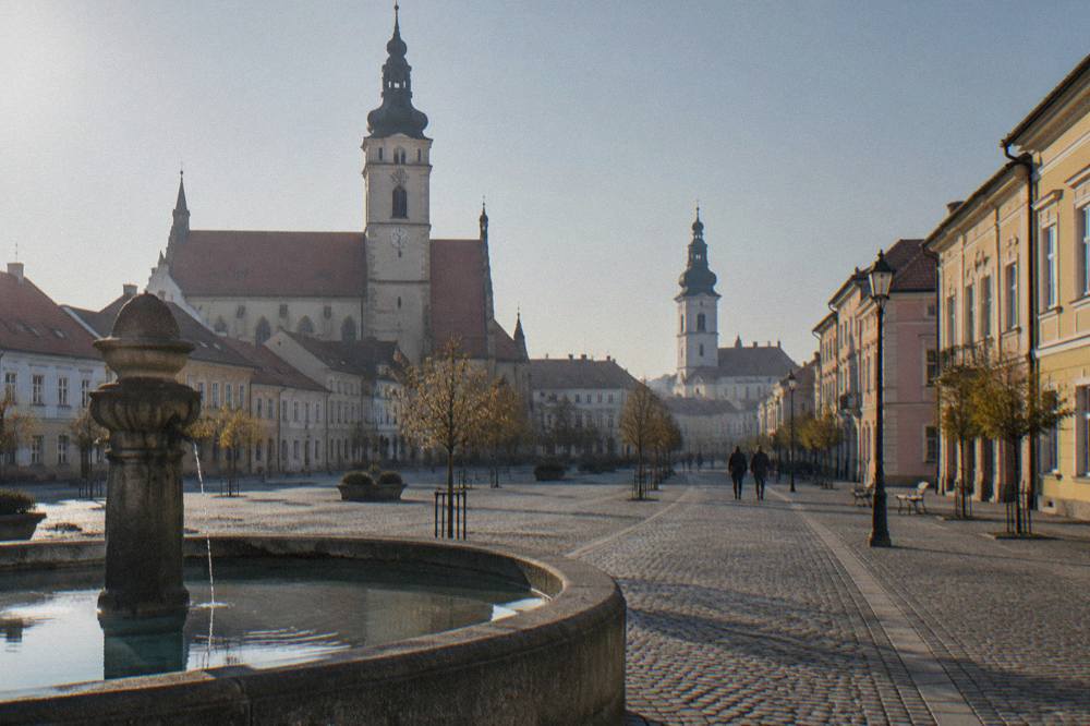 Cobbled square in a Slovak town with pastel townhouses and a church tower