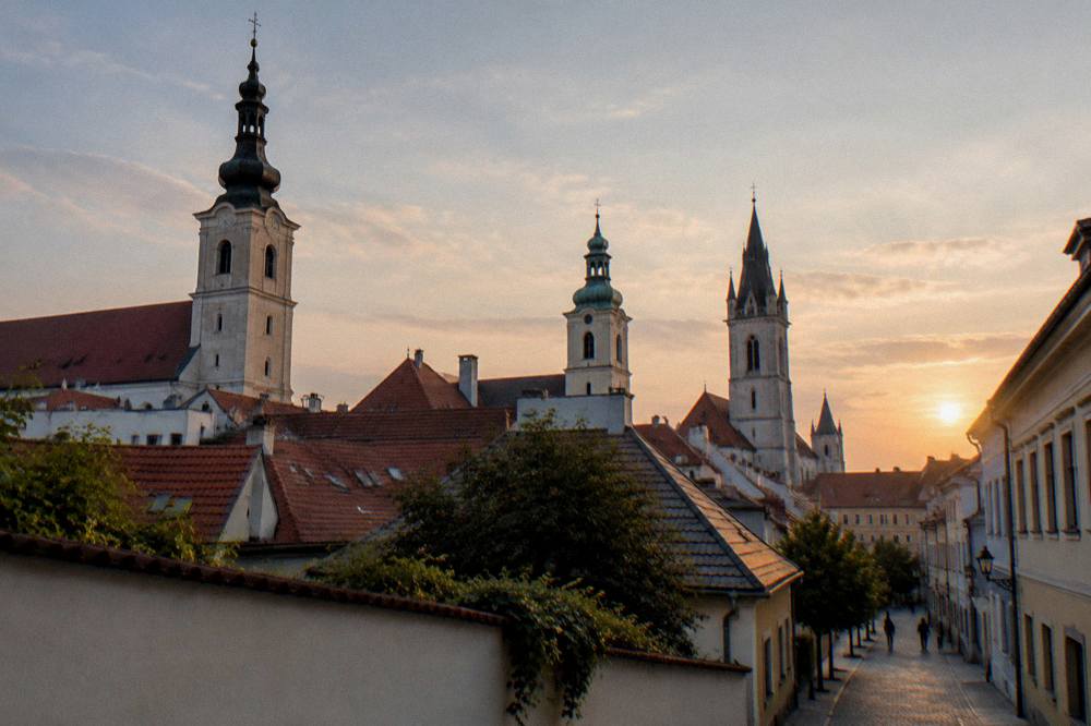 Church towers of a Slovak town seen across rooftops at dusk