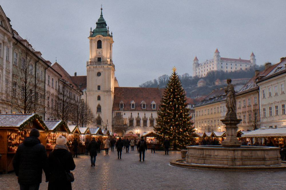 Christmas market stalls and a decorated tree on Hlavné námestie in Bratislava at dusk