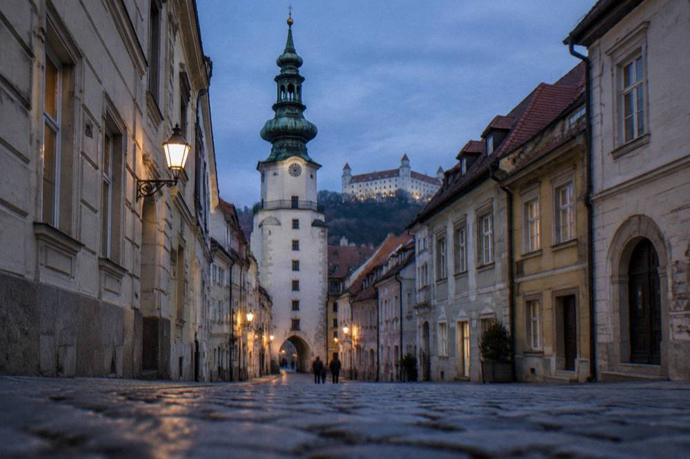 The tower of Michael's Gate rising over a narrow old town street