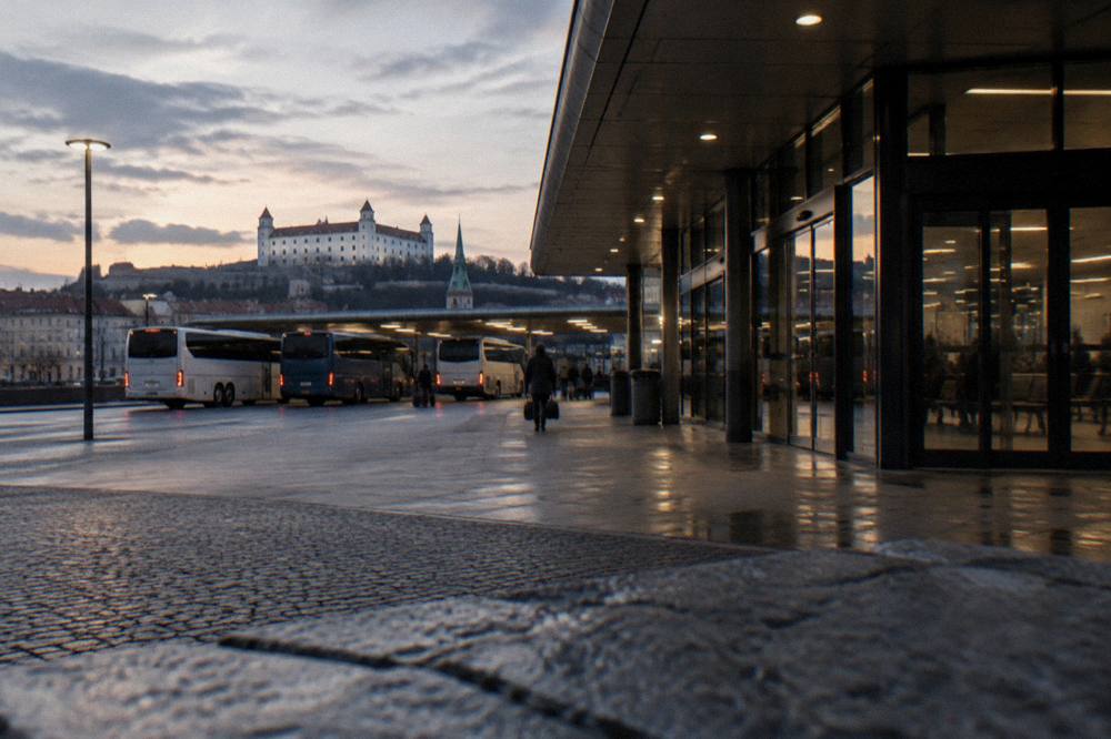 Evening view of a coach terminal entrance with lit signage in Bratislava