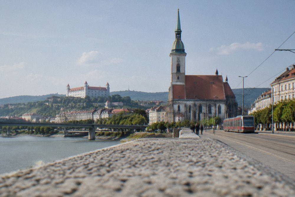 A hilltop castle above a small town seen from a river valley