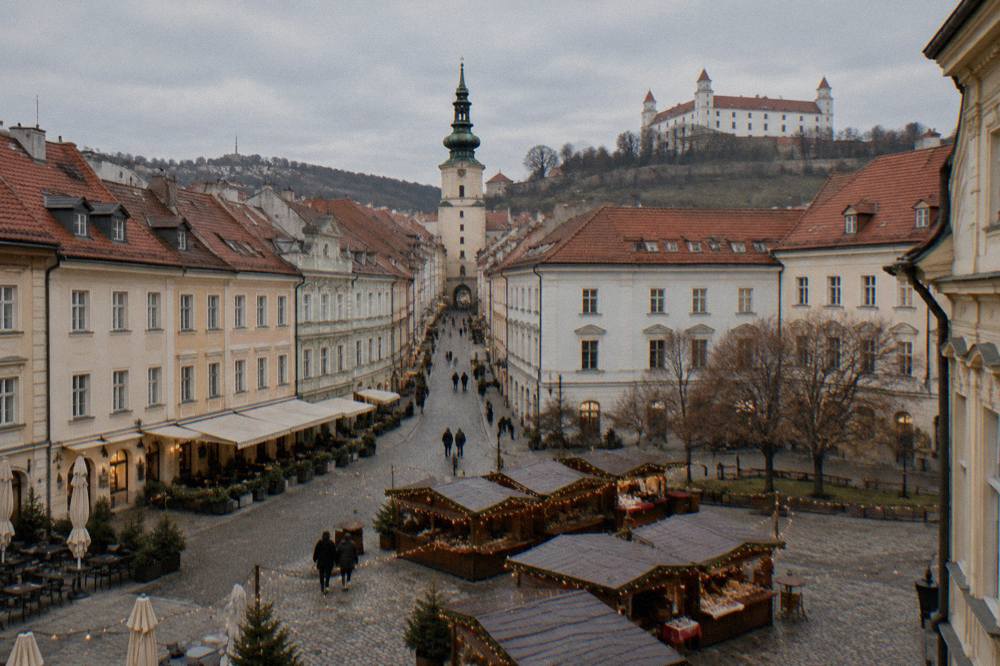 Wooden market stalls with string lights lining a square in the Bratislava Old Town