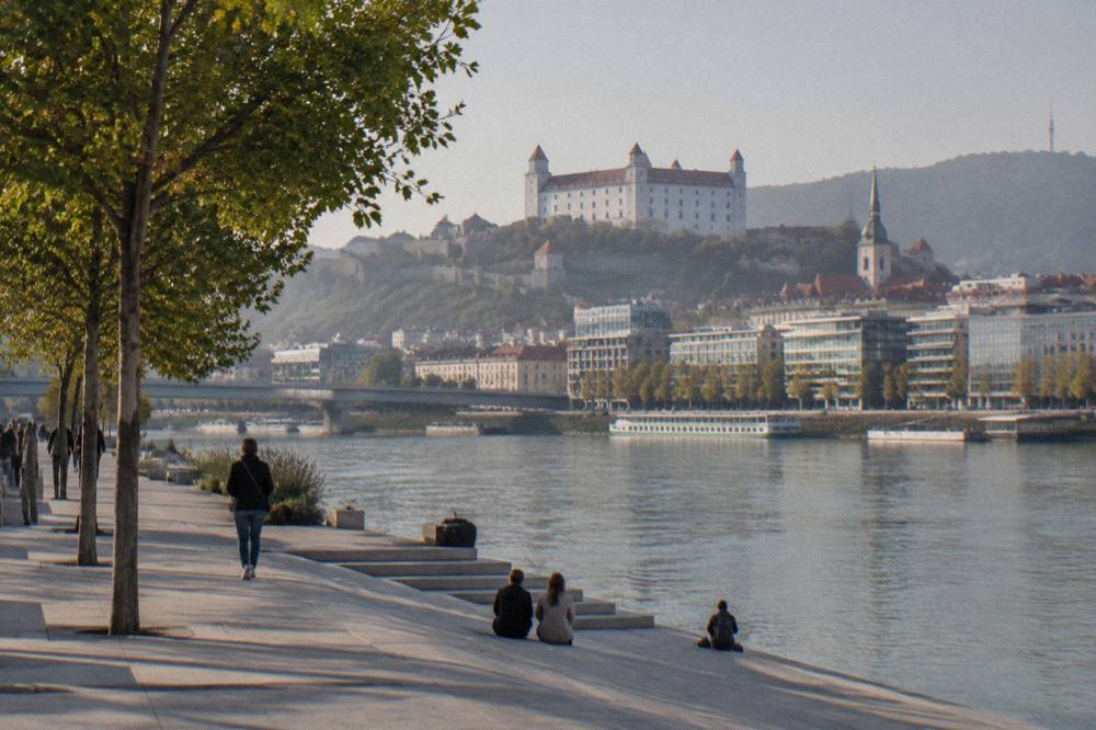 Hilltop castle above a small Slovak town seen from a river valley