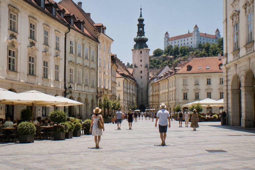 Visitors walking across the main square in Bratislava Old Town on a warm afternoon