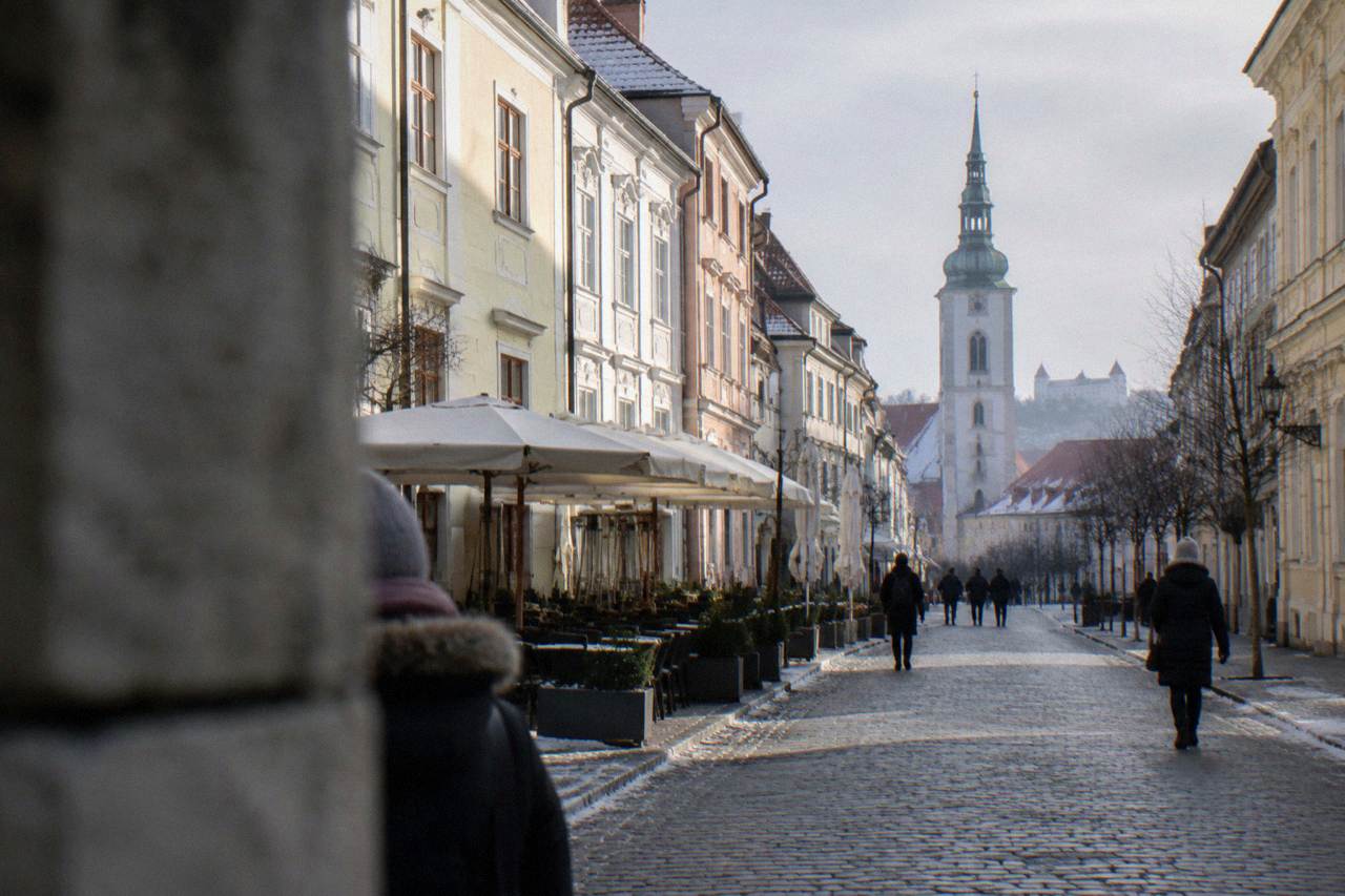 Bratislava Old Town square with a church tower under a pale winter sky