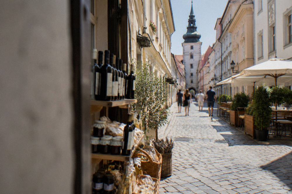 A shopfront display of bottled wine and local food products on an Old Town street