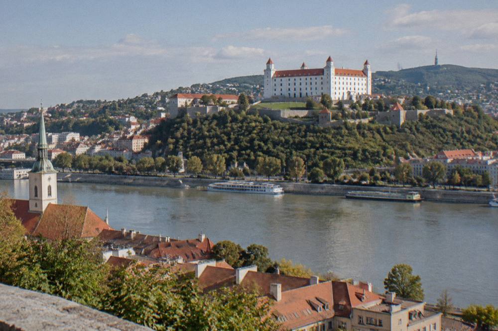 View across the Danube to Bratislava Castle on its hill above red rooftops