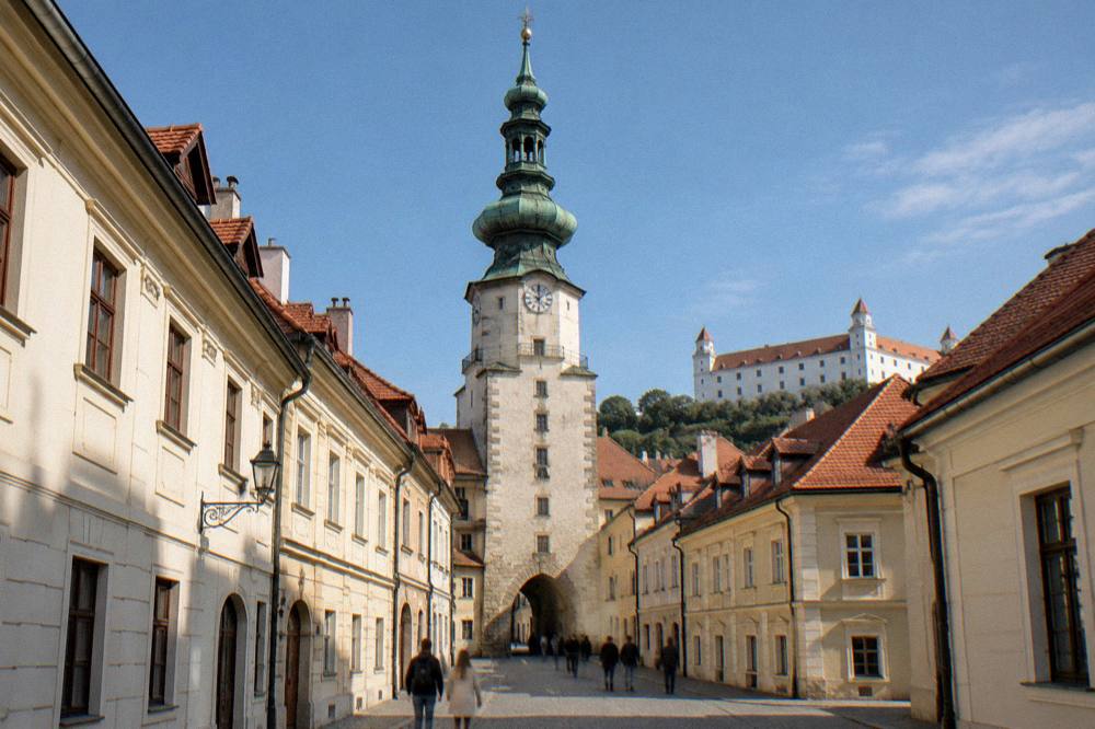 Stone tower of Michael's Gate rising over a narrow Old Town street in Bratislava