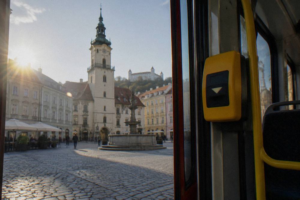 A yellow ticket validation machine mounted inside the door area of a Bratislava tram