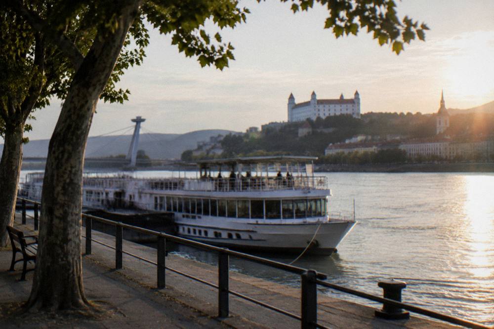A river boat at a berth on the Danube in evening light with city buildings behind