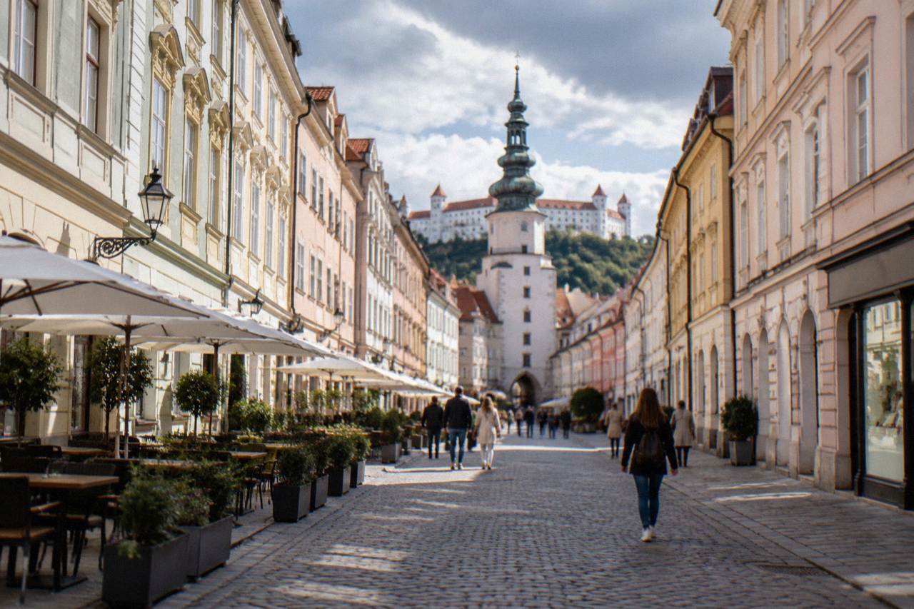 A pedestrian shopping street in Bratislava Old Town with shop fronts and people walking