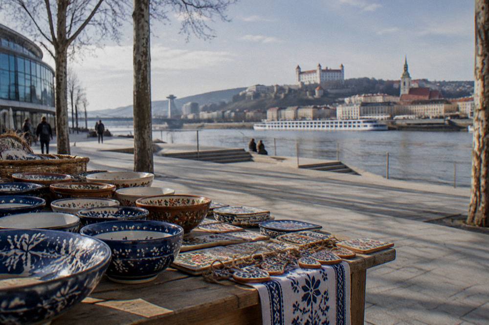 Handmade ceramic bowls and folk-pattern crafts displayed on a wooden table