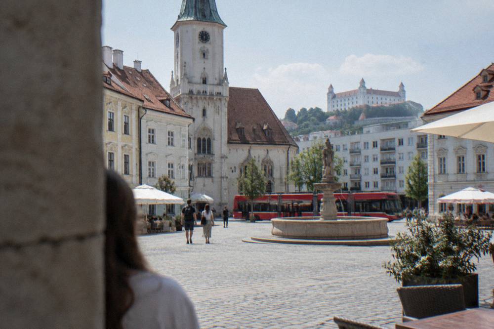 A red tram passing modern apartment buildings on a Bratislava street